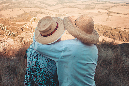 two-person-wearing-sunhats-sitting-on-rock-1756286 copy